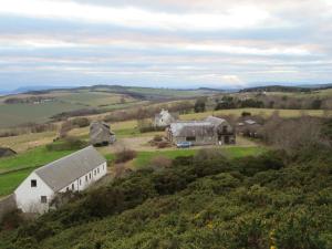 an aerial view of a farm with a white building at Kestrel, Longhouse Cottages in Rosemarkie +22 photos