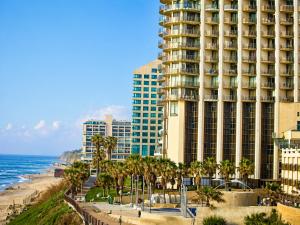 a view of a hotel and the ocean with palm trees at חדר על הים בהרצליה in Herzliya B