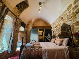 a bedroom with a bed in a room with stone walls at Dara Konagı in Mardin