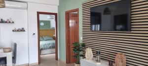 a room with a large television on a wall at HuesPet&You in Sanlúcar de Guadiana