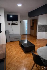 a living room with a couch and a table at Apartman City With 3 Bedooms And Free Parking in Negotin +1 photo