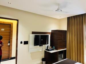 a hotel room with a bed and a flat screen tv at Hotel Hrishikesh High Tapovan in Rishīkesh +33 photos