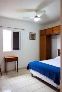 a bedroom with a bed and a table and a window at Hostel X20 in Arraial do Cabo