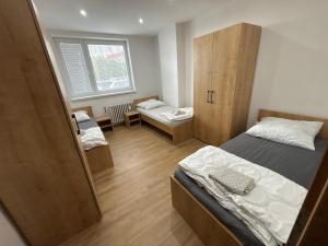 a small room with two beds and a cabinet at Apartmán REBEKA in Holíč