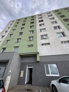 a tall green building with a car parked in front of it at Apartmán REBEKA in Holíč