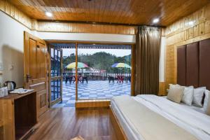 a bedroom with a bed and a patio with umbrellas at Hotel Dalhousie Delight in Dalhousie +9 photos