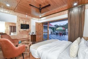 a bedroom with a bed and a balcony with a table at Hotel Dalhousie Delight in Dalhousie