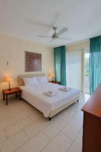 a bedroom with a large white bed with blue curtains at Bayview Terraces Cozy 1BR Haven in Limassol