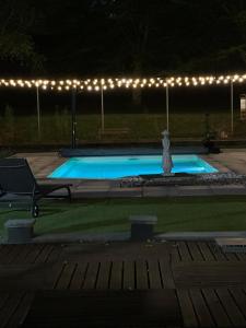 a swimming pool at night with lights around it at Chambres d'hôtes les Boulommiers in Samois-sur-Seine