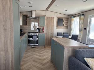 a kitchen with green cabinets and a counter top at Hardys Caravan Park in Ingoldmells +29 photos