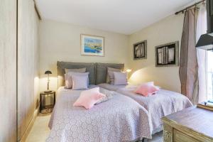 two beds in a bedroom with pink pillows at Appartement Centre de Saint-Tropez in Saint-Tropez