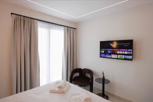 a bedroom with a bed and a tv on the wall at The Grand Blue Boutique Hotel in Missolonghi