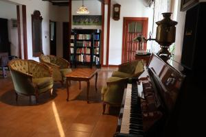 a living room with a piano and chairs at Agroturystyka u Oli in Smolany Dąb