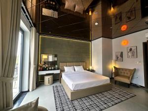 a bedroom with a large bed and a chair at DOS GATOS Hotel in Ðố Sơn