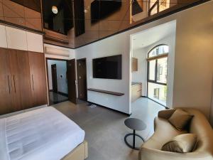 a bedroom with a bed and a couch and a tv at DOS GATOS Hotel in Ðố Sơn