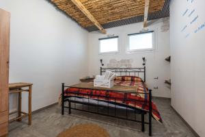 a bedroom with a bed in a room with two windows at Kasa Kalagonis in Maracalagonis
