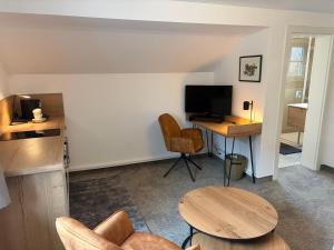 a living room with a table and a desk with a computer at Pension Schiessling in Anif
