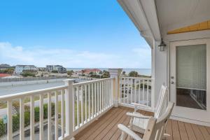 a balcony with two chairs and a view of the ocean at Mystic Shore in Oak Island