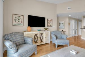 a living room with a couch and a tv at Mystic Shore in Oak Island