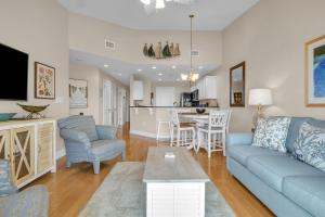 a living room with a blue couch and a kitchen at Mystic Shore in Oak Island +26 photos