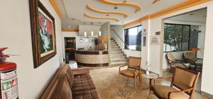 a living room with a couch and chairs and a kitchen at Esplendor Palace Hotel in Vitória da Conquista