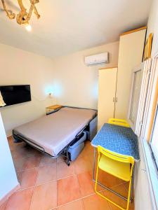 a room with a bed and a table and a tv at Wild Paradise in Costa Paradiso
