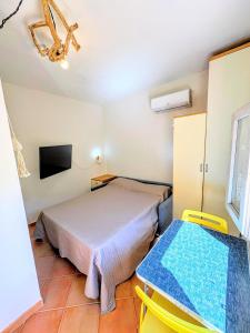 a bedroom with a bed and two yellow chairs at Wild Paradise in Costa Paradiso +30 photos