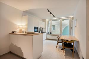 a kitchen with white cabinets and a wooden table at Markt 5 in Lier