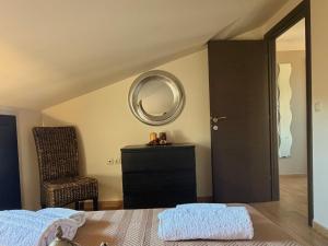 a bedroom with a bed and a mirror and a chair at VASILICA Apartments in Ierissos +9 photos