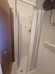 a shower with a glass door in a bathroom at BeaMare - Monolocale - Massimo tre ospiti con posto spiaggia - Studio Apartment - Max 3 people with 1 private umbrella and two SunBeds at the private beach of Eraclea Mare in Eraclea Mare