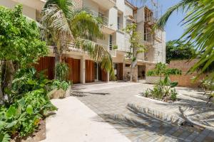 an empty courtyard of a building with palm trees at Hola Donceles Suites in Cancún