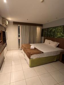 a bedroom with a large bed and a television at Flat Mercure Nova Iguaçu in Nova Iguaçu +43 photos