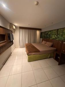 a bedroom with a bed and a television in it at Flat Mercure Nova Iguaçu in Nova Iguaçu