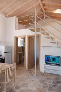 ein Wohnzimmer mit Fernseher und Treppe in der Unterkunft Elichrysos house in Kagkátika