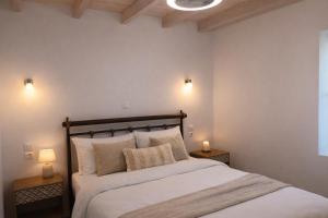 ein Schlafzimmer mit einem großen Bett und zwei Lampen auf Tischen in der Unterkunft Elichrysos house in Kagkátika