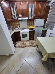 a small kitchen with wooden cabinets and white appliances at Krasaqua in Pogradec