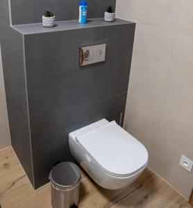 a bathroom with a white toilet and a trash can at Pod Hajom 101 in Liptovský Mikuláš +3 photos