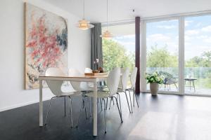a dining room with a table and white chairs at Blueberry Living - Design-Apartments am Starnberger See, Natur & Erholung, Privatparkplatz, nur 400 m zum See in Tutzing