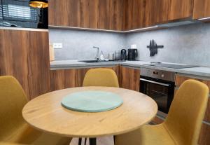 a kitchen with a wooden table and yellow chairs at Pod Hajom 101 in Liptovský Mikuláš