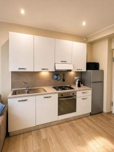 a kitchen with white cabinets and a stainless steel refrigerator at BiloVarazze with Terrace in Varazze