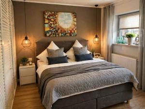 a bedroom with a large bed and a painting on the wall at Premium Lodge nahe Cochem - 5-Sterne- Ferienwohnung - 149 qm - für 2-6 Gäste in Greimersburg