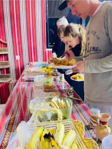 a group of people standing around a buffet with food at Wadi rum trips in Wadi Rum +53 photos