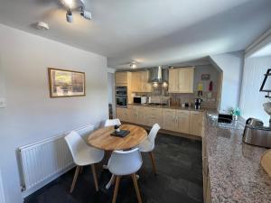 a kitchen with a wooden table and white chairs at Forth, Pittenweem in Pittenweem