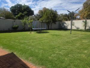 a yard with a bench in the grass at Kirrin Cottage in Benoni in Benoni