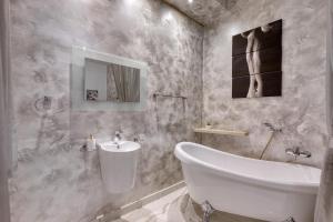 a bathroom with a white tub and a sink at Staytopus St Elizabeth - Modern Apartment - in Xewkija