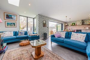 a living room with blue couches and a table at Saoirse in East Wittering