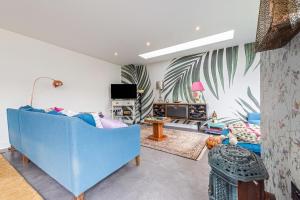 a living room with a blue couch and a tv at Saoirse in East Wittering