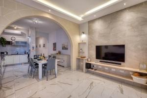 a kitchen and dining room with a table and a tv at Staytopus St Elizabeth - Modern Apartment - in Xewkija +26 photos