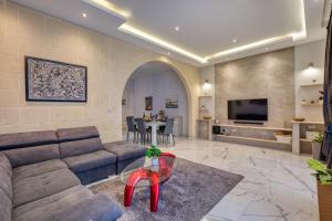 a living room with a couch and a table at Staytopus St Elizabeth - Modern Apartment - in Xewkija