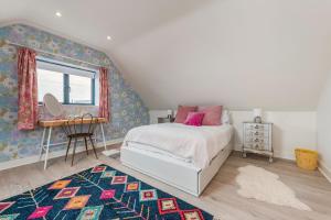 a bedroom with a bed and a window and a rug at Saoirse in East Wittering